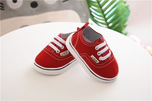 zapatos de vestir Vans de color rojo sobre mesa blanca
