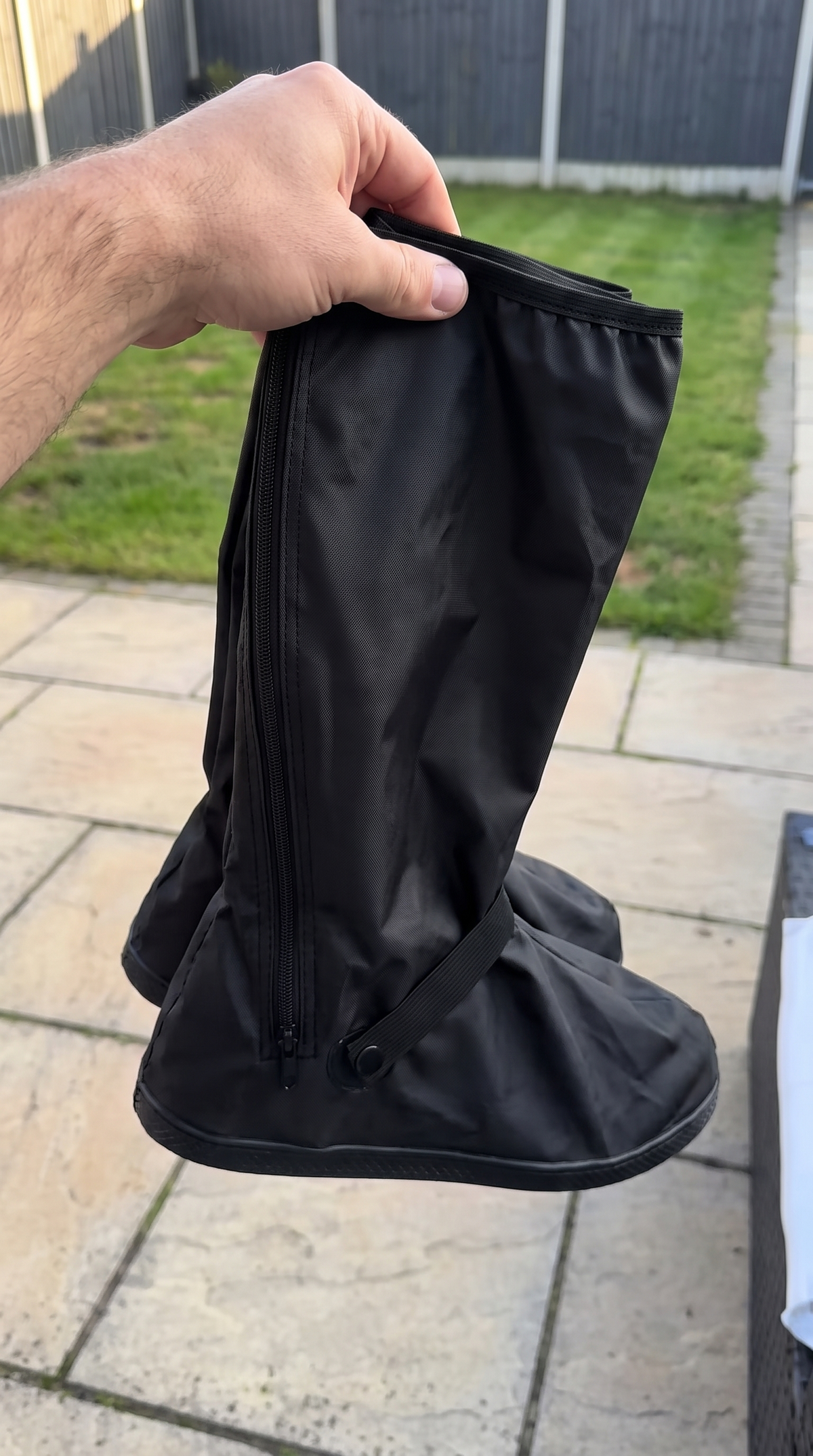 Cubrebotas impermeable plegado en la mano
