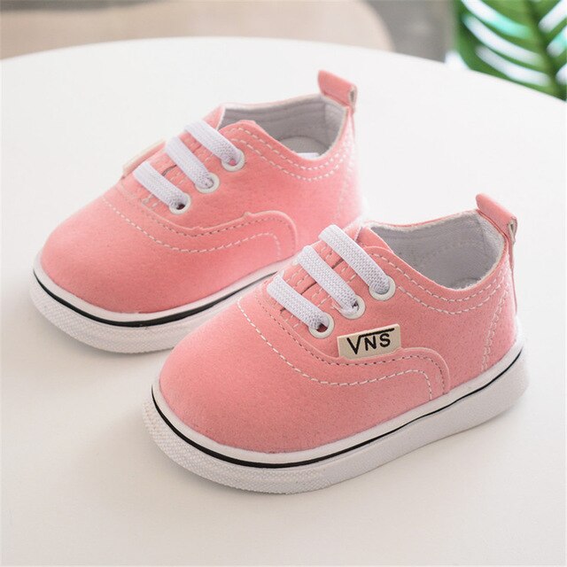 zapato color rosa Vans sobre mesa blanca