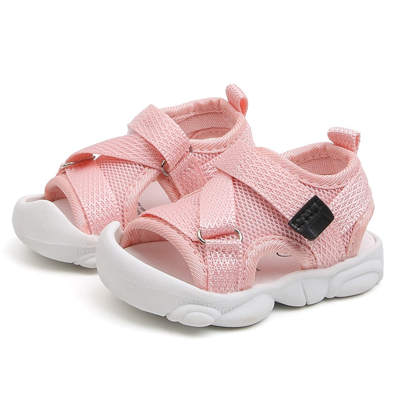 sandalias rosas de bebe sobre fondo blanco